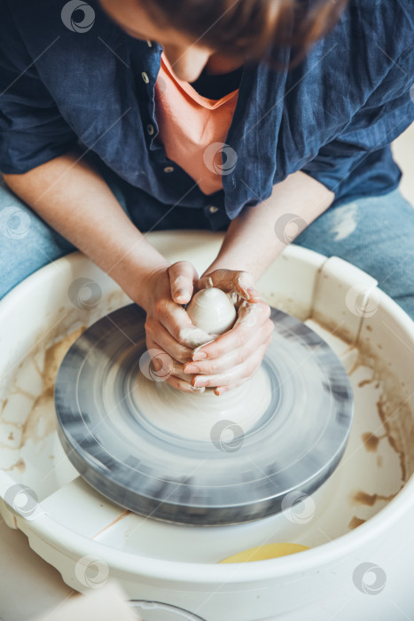 Скачать Женщина-керамист за гончарным кругом в мастерской фотосток Ozero