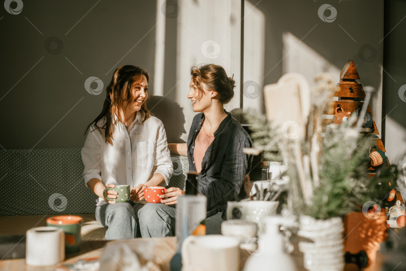 Скачать Две женщины пьют чай на солнышке в уютной обстановке фотосток Ozero