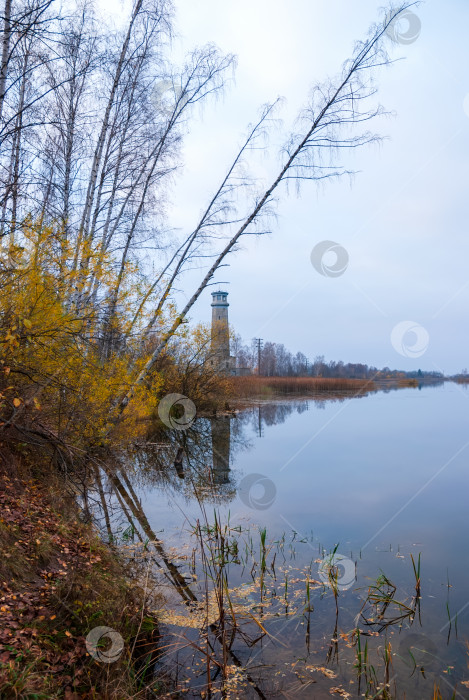 Скачать Осенний пейзаж. Маяк отражается в воде озера. фотосток Ozero