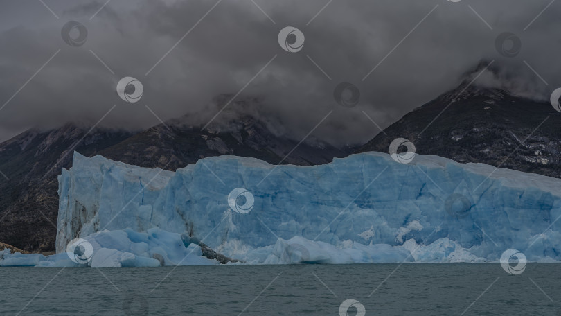 Скачать Впечатляющий голубой ледник на фоне гор и тумана. фотосток Ozero