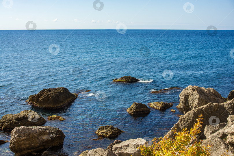 Скачать Скалистый берег Черного моря. Мыс Алчак. Дикая природа вблизи древнего города, построенного генуэзцами. Бархатный сезон в Судаке в Крыму. Огромные камни и валуны в море и на фоне моря. Крупный план. фотосток Ozero