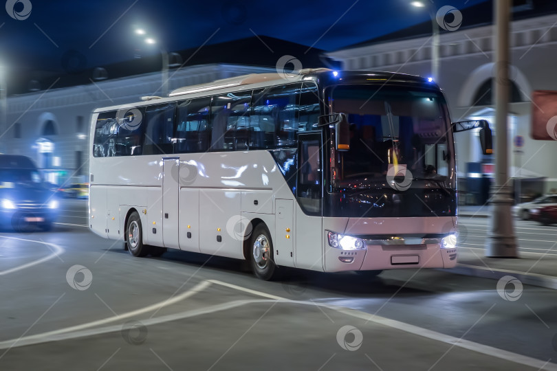 Скачать Туристический автобус движется ночью по городской улице фотосток Ozero