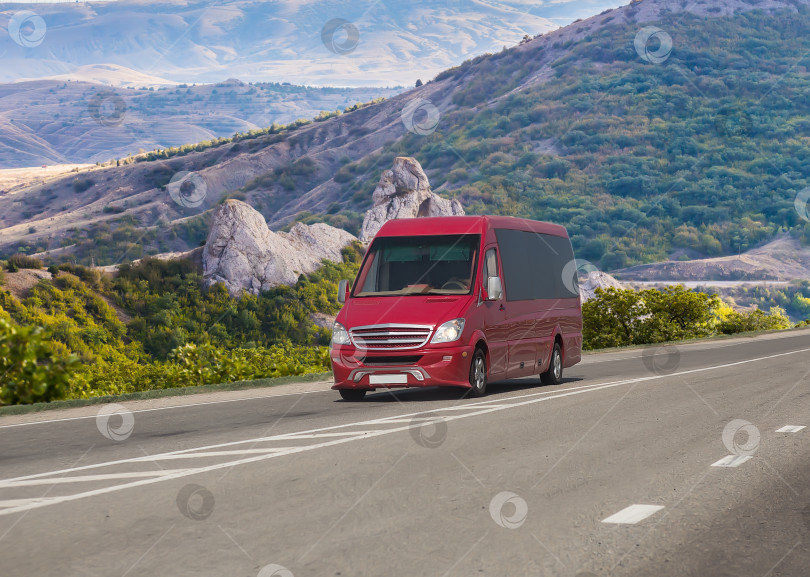 Скачать Красный микроавтобус движется по дороге в горах фотосток Ozero