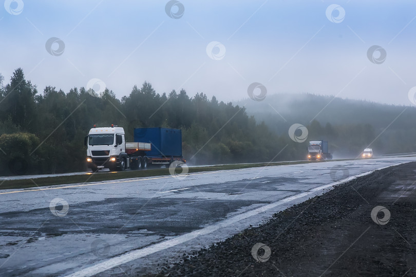 Скачать грузовики с контейнерами едут в тумане по шоссе фотосток Ozero