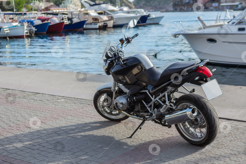 Скачать Мотоцикл на пирсе возле пришвартованных яхт фотосток Ozero