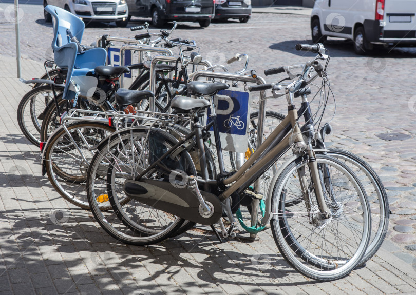 Скачать Велосипеды на велопарковке на тротуаре фотосток Ozero