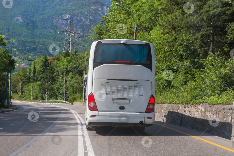 Скачать Туристический автобус движется по пригородному шоссе фотосток Ozero