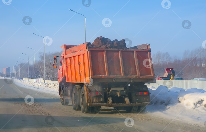 Скачать Грузовик перевозит грунт по зимней дороге фотосток Ozero