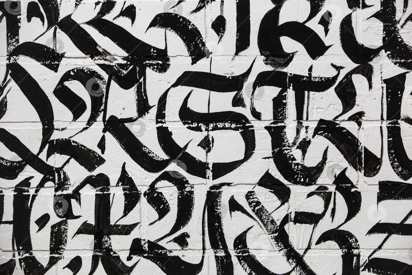 Скачать Буквы готическим шрифтом на белой кирпичной стене фотосток Ozero
