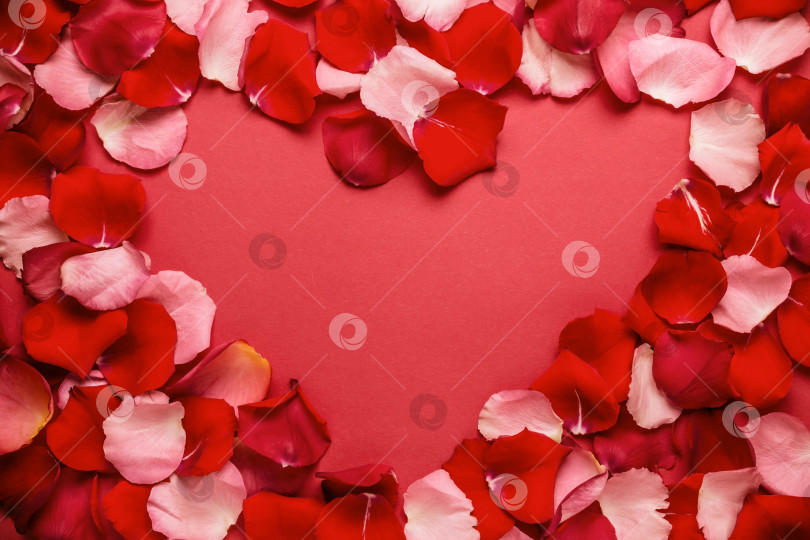 Скачать Любовный романтический фон. сердечная рамка из лепестков роз на красном фоне. фотосток Ozero