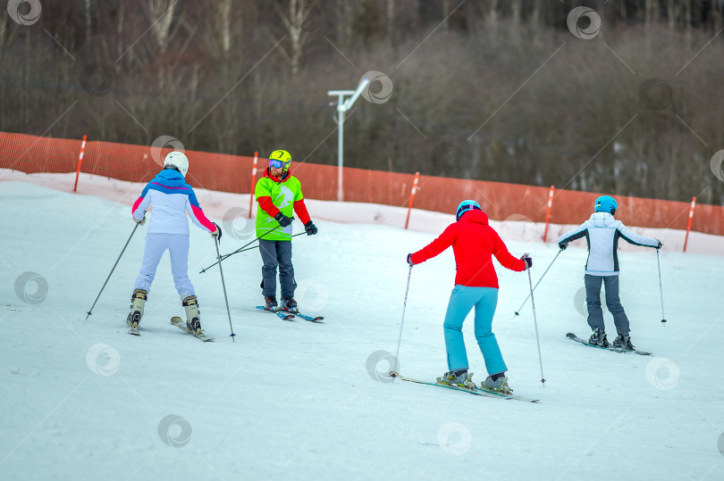 Скачать Череповец, Россия, 02 января 2023 года, группа людей спускается на лыжах с горнолыжного склона или трассы. Зимние лыжные каникулы на Грицинской горе. фотосток Ozero