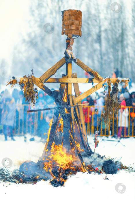 Скачать Сжигание деревянной куклы - чучела Масленицы в огне костра.Масленица - традиционный славянский праздник окончания зимы и начала весны фотосток Ozero