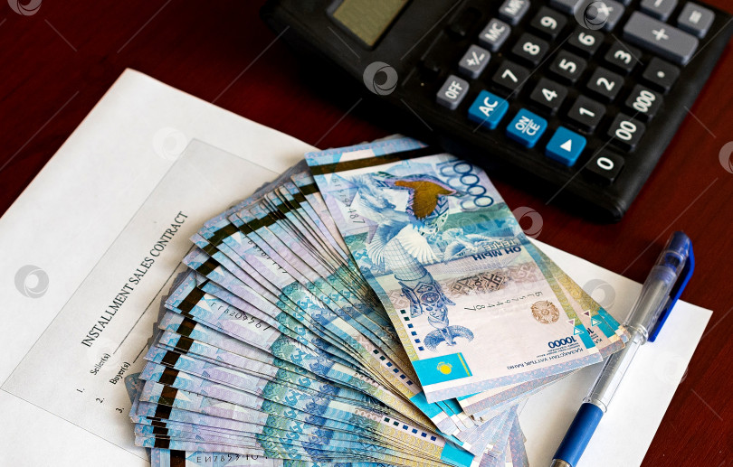 Скачать Тенге. Бумажные казахские деньги и калькулятор на столе крупным планом. фотосток Ozero