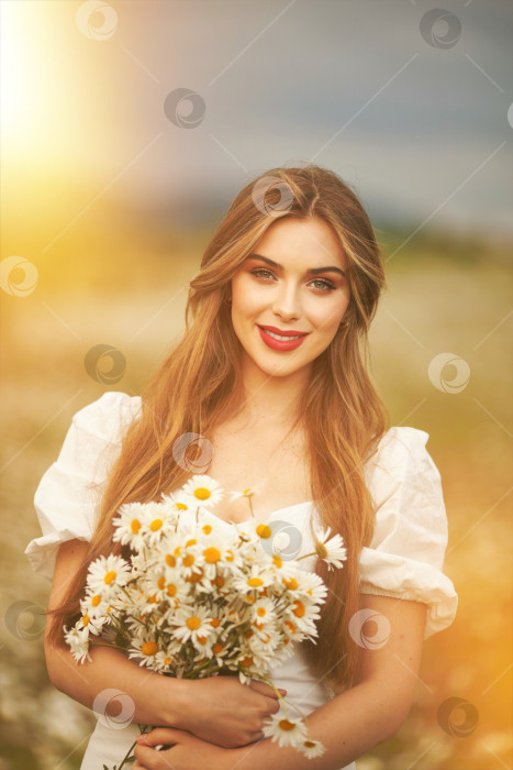 Скачать Женщина в поле с цветами. Красивая девушка в поле с маргаритками. фотосток Ozero