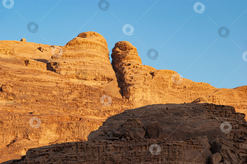 Скачать Волшебные горные пейзажи пустыни Вади Рам, Иордания. Горы в безжизненной пустыне напоминают марсианские кратеры.  Песок красивого розового цвета, а скалы красные. Есть место для текста. фотосток Ozero