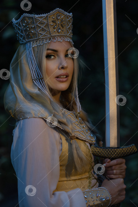 Скачать Портрет красивой девушки в кокошнике (короне) в традиционном русском стиле и с мечом в руках. фотосток Ozero