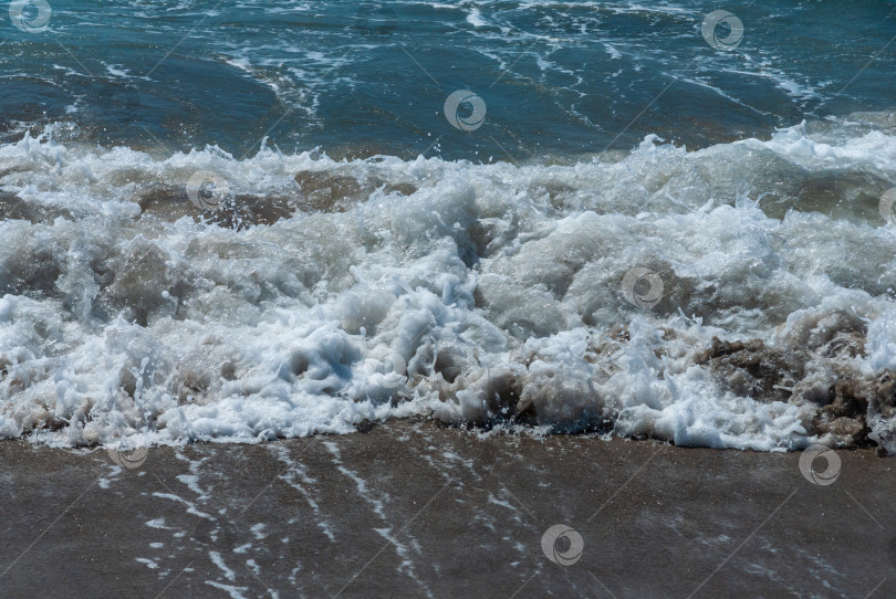 Скачать Побережье Средиземного моря в Фетхие, Турция. Бирюзовые пенистые волны набегают на песчаный пляж. Крупный план. фотосток Ozero
