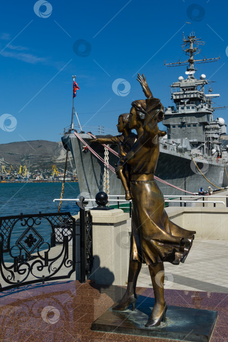 Скачать Памятник жене моряка на набережной в Новороссийске. Скульптура красивой женщины с ребенком на фоне крейсера "Михаил Кутузов". Новороссийск, Россия - 15 сентября 2021 года фотосток Ozero