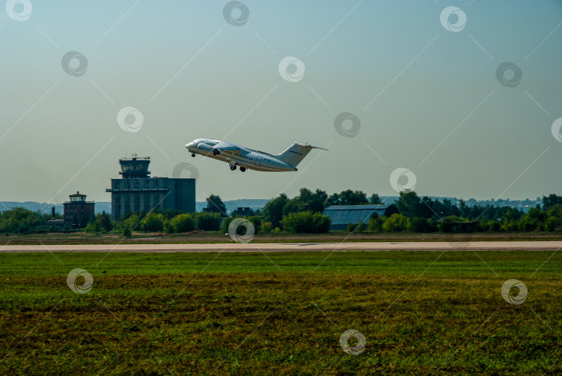 Скачать Украинский двухмоторный реактивный пассажирский самолет Ан-148 взлетает с бетонной взлетно-посадочной полосы. Самолет над взлетно-посадочной полосой. Выпущено шасси. Размытый фон. МАКС-2007. фотосток Ozero