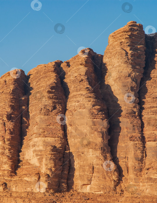 Скачать Волшебные горные пейзажи пустыни Вади Рам, Иордания. Горы в безжизненной пустыне напоминают марсианские кратеры.  Песок красивого розового цвета, а скалы красные. Есть место для текста. фотосток Ozero