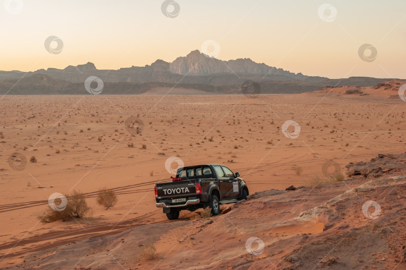 Скачать Иордания. Полноприводные автомобили в безлюдной пустыне Вади-Рам. Горы в безжизненной пустыне напоминают марсианские кратеры. Размытый фон. Выборочный фокус. Вади-Рам, Иордания - 05 декабря 2009 г. фотосток Ozero