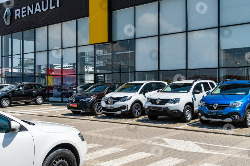 Скачать Автосалон Renault с припаркованными автомобилями. Название Renault с логотипом на фасаде здания в Мега Адыгея. Краснодар, Россия - 04 августа 2022 г. фотосток Ozero