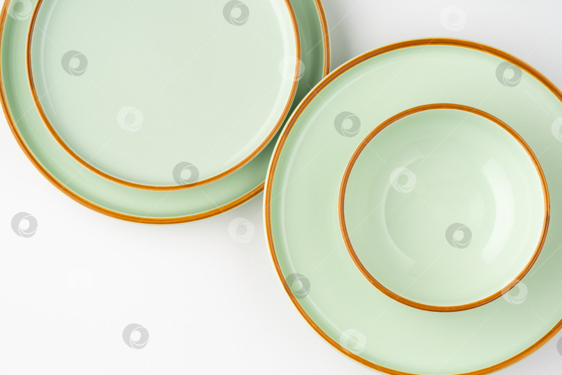 Скачать Набор керамической посуды пастельно-зеленого цвета с оранжевыми контурами. Вид сверху фотосток Ozero