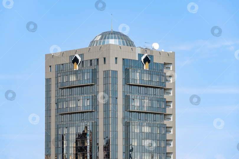 Скачать Офисное здание крупнейшей нефтегазовой компании "Роснефть". Небоскреб с остекленным фасадом. В верхней части на каждой стене размещен логотип компании "Роснефть". фотосток Ozero