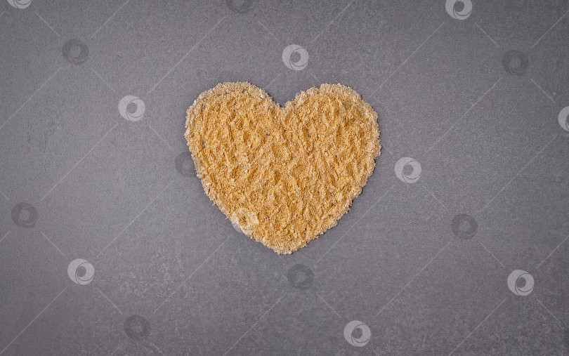 Скачать Вид сверху на золотистую пудру в форме сердца на сером фоне с пространством для копирования фотосток Ozero
