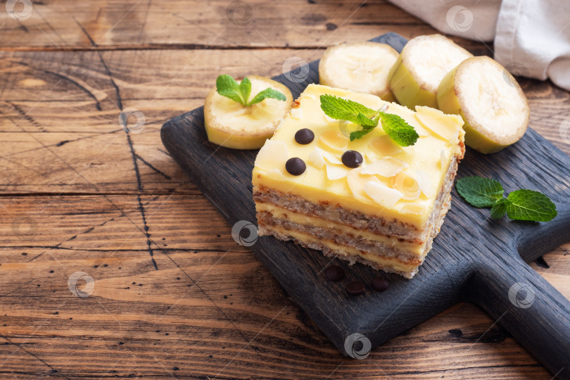 Скачать Банановый бисквит с орехами и шоколадными каплями. Вкусный сладкий десерт к чаю, деревянный фон. вид сверху, место для копирования. фотосток Ozero