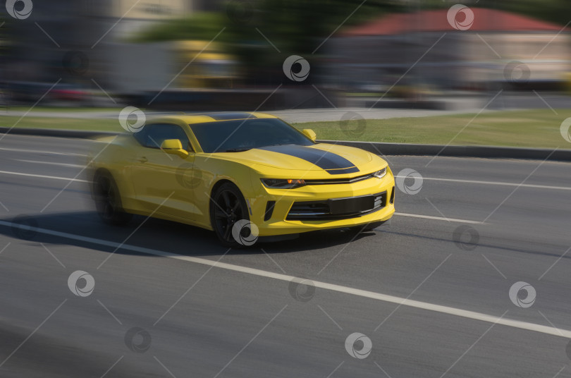 Скачать Желтый спортивный автомобиль мчится по городской улице фотосток Ozero