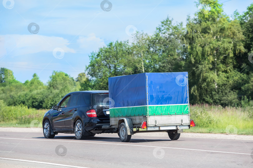 Скачать кроссовер с прицепом движется по шоссе фотосток Ozero