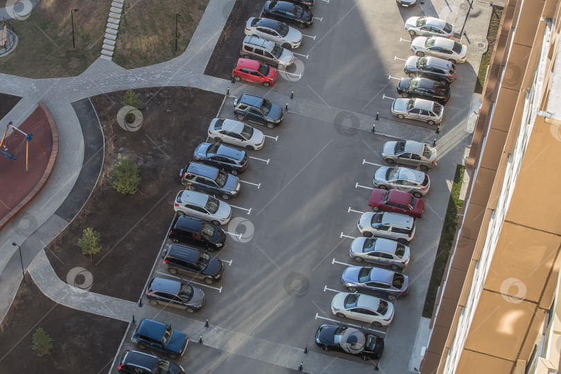 Скачать Автомобили припаркованы во дворе жилого многоквартирного дома. фотосток Ozero