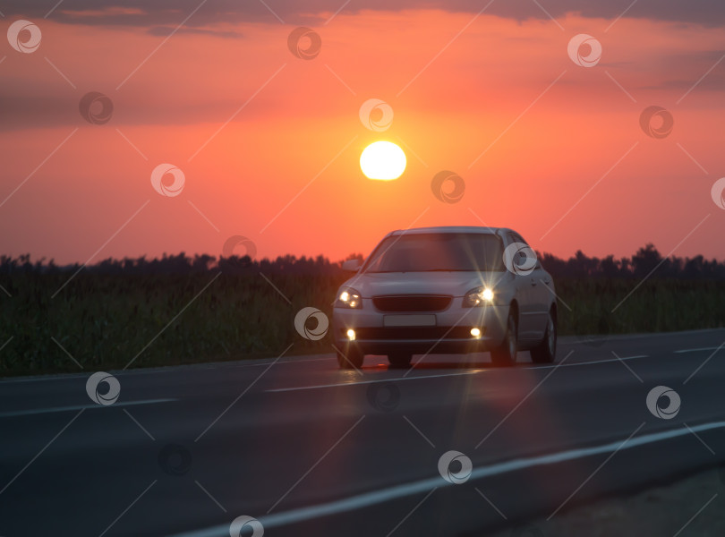 Скачать Автомобиль проезжает на закате по шоссе фотосток Ozero