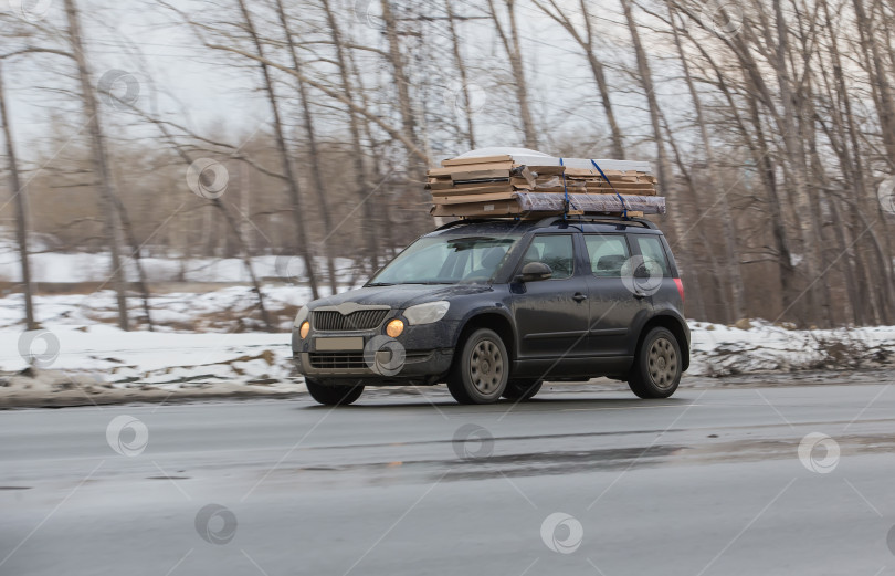 Скачать Автомобиль перевозит картонные коробки в багажнике по зимней дороге фотосток Ozero