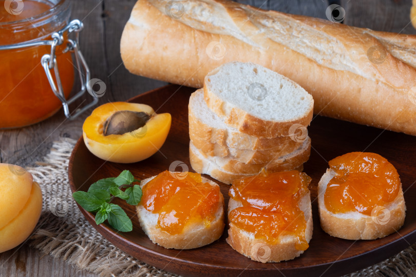 Скачать Тосты из хлеба с абрикосовым джемом и свежими фруктами с мятой на деревянном столе. Вкусный завтрак фотосток Ozero