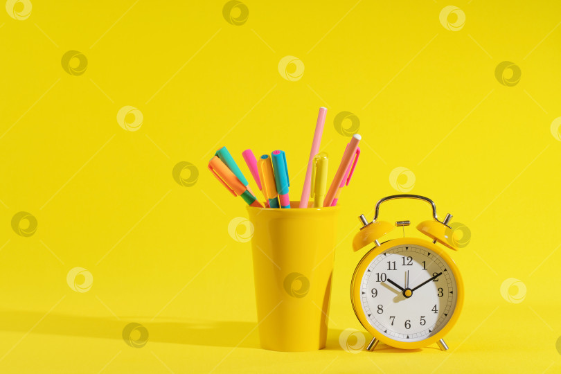 Скачать канцелярские принадлежности, яблоко и ретро-будильник на ярко-желтом фоне фотосток Ozero