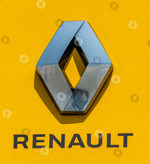 Скачать Логотип автопроизводителя Renault на желтом вертикальном пилоне. Пилон с логотипом между шоссе и автостоянкой перед сервисным центром Renault в Адыгее. фотосток Ozero