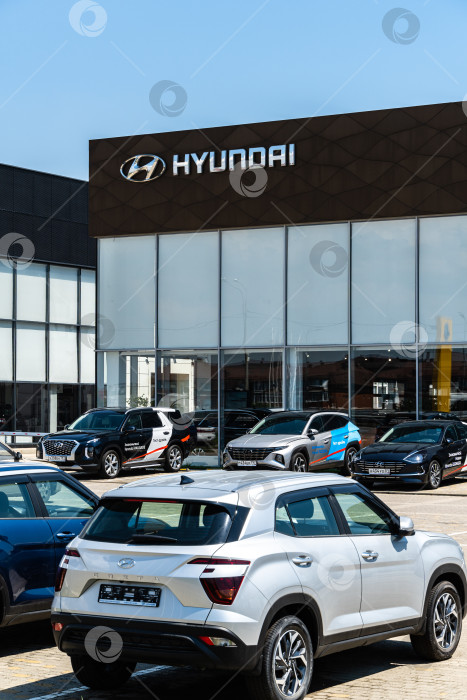 Скачать Автомобили разных цветов припаркованы у дилерского центра Hyundai. На фасаде здания надпись Hyundai с логотипом. Дилерский центр Hyundai. Мега Адыгея. фотосток Ozero