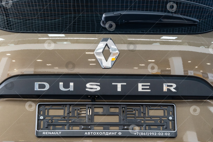Скачать Бежевый внедорожник Renault Duster в автосалоне дилерского центра Renault. Крупный план надписи Duster на задней двери автомобиля. Автосалон Renault в Мега Адыгея. фотосток Ozero