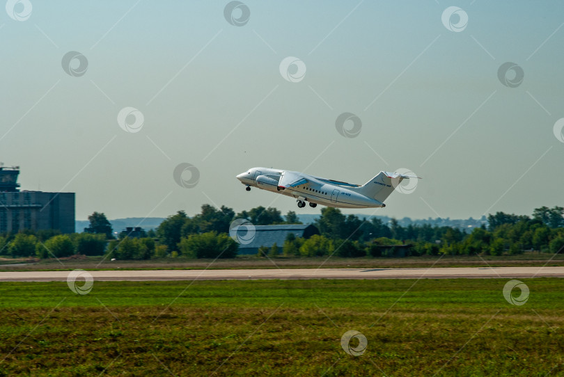 Скачать Украинский двухмоторный реактивный пассажирский самолет Ан-148 взлетает с бетонной взлетно-посадочной полосы. Самолет над взлетно-посадочной полосой. Выпущено шасси. Размытый фон. МАКС-2007. фотосток Ozero