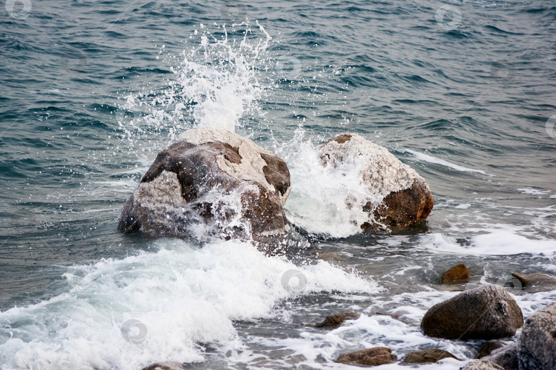 Скачать Мертвое море. Иордания. Крупный план. Кристаллы соли на огромных валунах вдоль побережья. Крупный план. Каменные пляжи вдоль побережья Мертвого моря омываются пенистыми изумрудными водами. фотосток Ozero