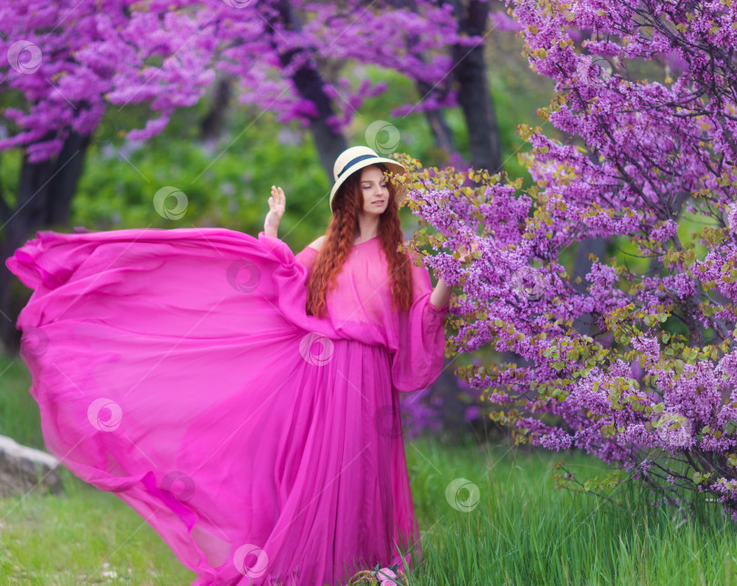 Скачать Женщина в розовом платье и летней шляпке на открытом воздухе. Красивая невеста в свадебном платье в парке весеннего цветения. Модная девушка в роскошной одежде на фоне зеленой природы фотосток Ozero
