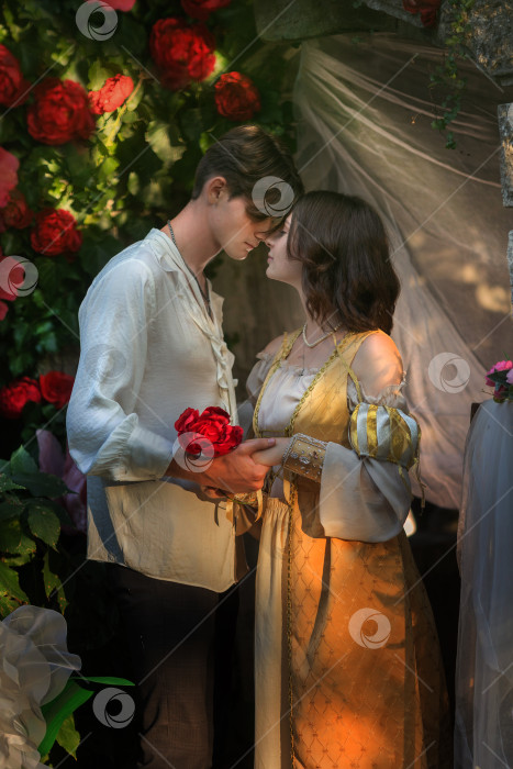 Скачать влюбленные парень и девушка обнимаются среди цветов и свечей. винтажная романтическая фотография фотосток Ozero