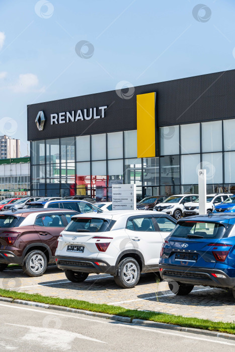 Скачать Автомобили Renault разных цветов припаркованы возле дилерского центра Renault. На фасаде здания надпись Renault с логотипом. Дилерский центр Renault. Мега Адыгея. фотосток Ozero