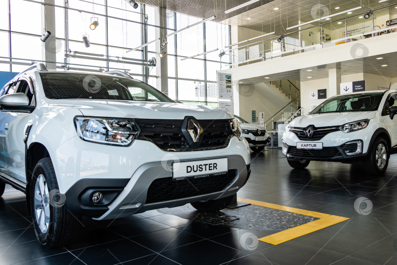 Скачать Белый внедорожник Renault Duster в демонстрационном зале дилерского центра Renault. Автомобиль крупным планом. Слева внедорожник Renault Capture. Мега Адыгея. фотосток Ozero