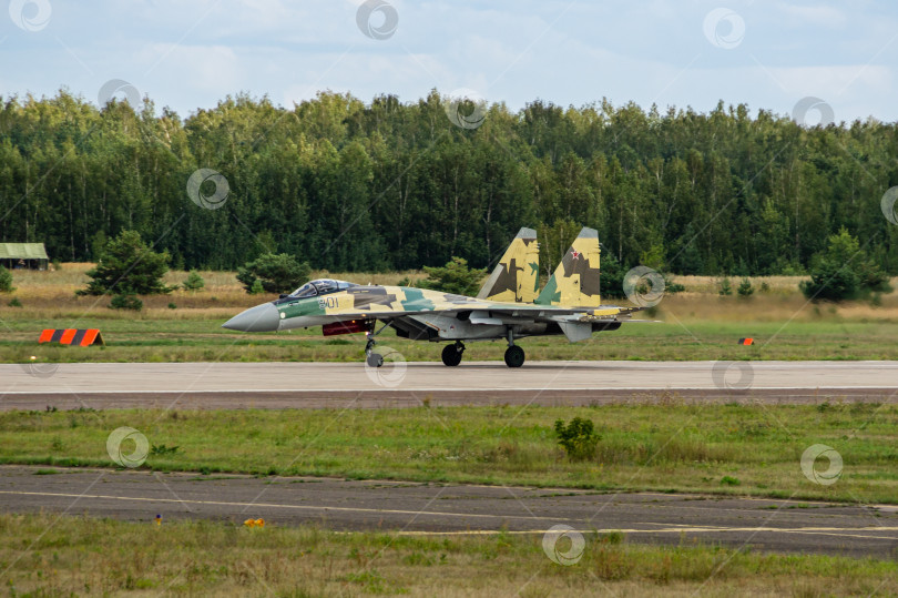 Скачать Советско-российский многоцелевой истребитель Су-35 (НАТО - Flanker-E) поколения "четыре плюс" движется по бетонной взлетно-посадочной полосе в направлении взлета. 100 лет Военно-воздушным силам России. фотосток Ozero