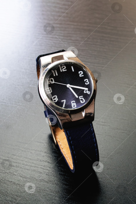 Скачать Синие наручные часы на черном деревянном столе фотосток Ozero