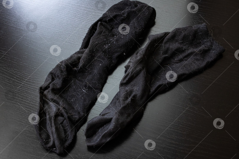 Скачать Грязные черные носки на деревянном столе фотосток Ozero