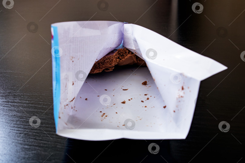 Скачать Съеденный шоколад в упаковке на деревянном фоне фотосток Ozero